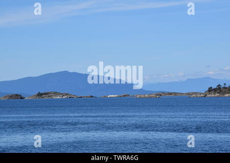 La vista dalla spiaggia in Lantzville sull'Isola di Vancouver, guardando attraverso lo Stretto di Georgia con la terraferma Foto Stock