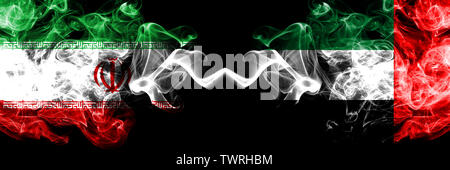 Iran vs Emirati Arabi Uniti, Emirati smoky mystic membri bandiere poste fianco a fianco. Spessa colorata fumi setosa bandiera combinazione di iraniano e Regno Foto Stock