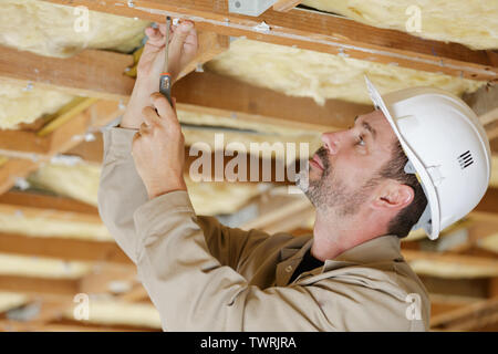 Builder maschio lavora su soffitto Foto Stock