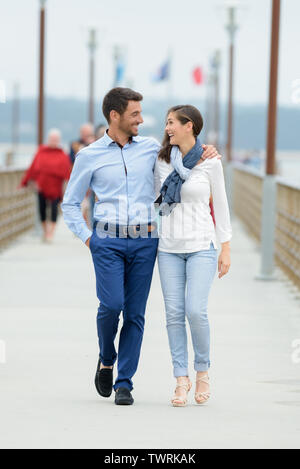 Un paio di camminare su un molo su un lago Foto Stock