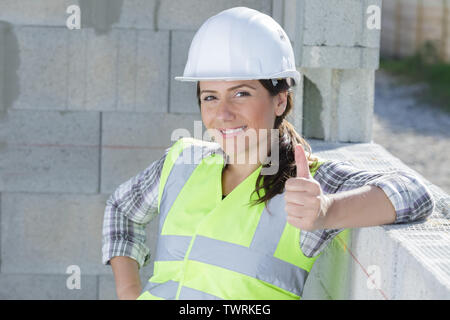 Allegro builder femmina mostra il pollice-up Foto Stock