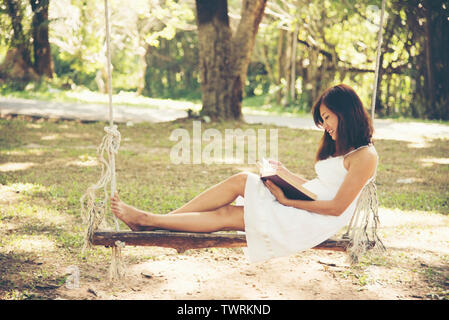 Donna relax leggendo un libro nel parco Foto Stock