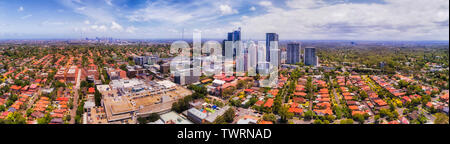 Panorama urbano della città di Sydney in una distanza all'orizzonte dietro Chatswood CBD circondato da strade residenziali e case in una giornata di sole. Foto Stock