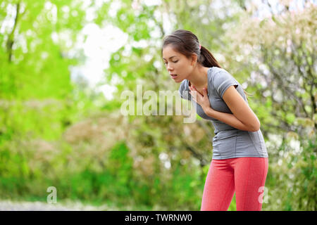 Nausea - nausea e mal malati runner vomito. Esecuzione di sentimento donna male circa a vomitare. Ragazza avente nausea dalla disidratazione o dolore al petto. Foto Stock