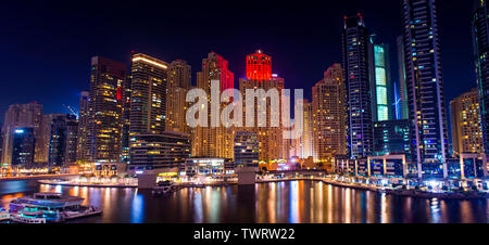 Colorata notte vista della citta' di Dubai Marina moderni edifici e lago in barca, yacht di lusso stile di vita incredibile architettura è il miglior posto per visitare il sito web Foto Stock