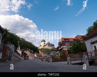 Karlstejn, Repubblica Ceca - 21 Giugno 2019: Medievale gotico e il castello di Karlstejn che sovrasta il villaggio in Boemia, Repubblica Ceca in Golden luce della sera Foto Stock