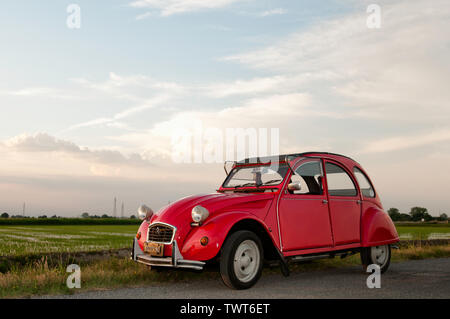 Red Citroën 2CV fotografato in ambiente rurale (Milano, Italia) Foto Stock