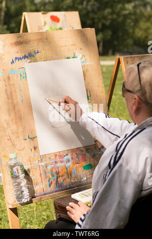 Coppia grey-haired donna richiama bozzetto floreale all'aperto in art studio nella giornata di sole. Mosca - Giugno 1, 2019. Hobby per i pensionati, programmi sociali per Foto Stock