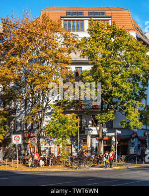 Berlin Friedrichshain, Boxhagener Strasse. Intimes Kino. Arte cinema con persone sedute a tavoli all aperto in autunno Foto Stock