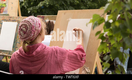 Donna matura disegna bozzetto floreale con matita in esterno e in studio d'arte. Mosca - Giugno 1, 2019. Hobby per i pensionati, programmi sociali per anziani pers Foto Stock