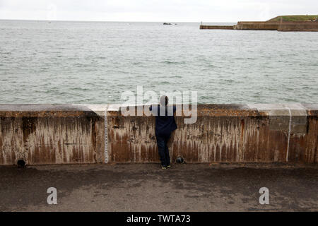 Eyemouth, Scozia - Ragazzo che guarda al mare presso la scena della pesca Eyemouth disastro del 1881 o 'Venerdì Nero" Foto Stock