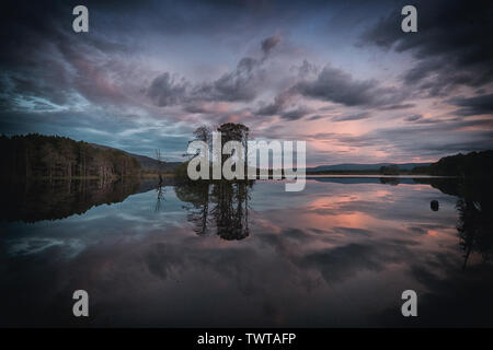 Cielo viola riflessioni in Loch Mallachie Foto Stock