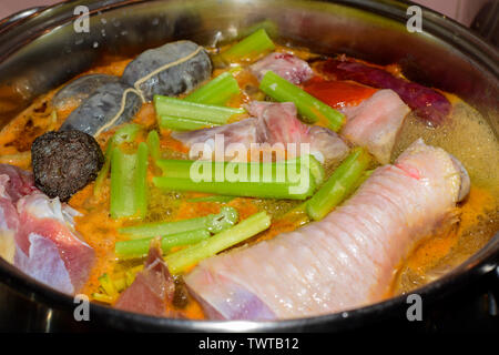 La cottura tradizionale spagnolo e di maiale spezzatino di pollo con salsiccia di sangue chorizo e verdure. Nutrizione cucina spagnola in pentola di cottura. Spagna, 2019. Foto Stock