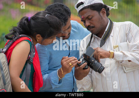 Bangalore, Karnataka India-June 04 2019 :fotografo indiano che mostra le foto ai clienti su foto sullo schermo della fotocamera, giovane guardando l'immagine Foto Stock