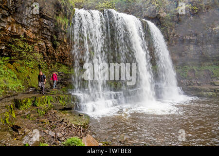 In certi momenti può essere possibile camminare dietro di Sgwd yr Eira sulla cascata le cascate a piedi nel Parco Nazionale di Brecon Beacons, Powys, Wales, Regno Unito Foto Stock