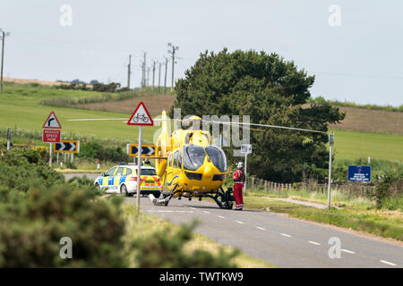 B9040 Hopeman, murene, UK. Il 23 giugno, 2019. Regno Unito. Questo è l'aereo ambulanza sulla B9040 Road a Hopeman Campo da Golf re la seguente dichiarazione di polizia. La polizia in Scozia desidera consigliare di una chiusura della strada sulla B9040 tra Hopeman e Lossiemouth, a causa di un traffico stradale incidente. La strada sarà chiuso fino a ulteriore avviso. Servizi di emergenza sono sulla scena. Credito: JASPERIMAGE/Alamy Live News Foto Stock