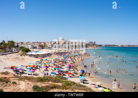 Occupato Mediterranean Beach a Playa Mil Palmeras, Pilar de la Horadada, Alicante, Spagna, Europa. Sun colorate sfumature di blu del cielo e del mare. Costa Blanca Foto Stock