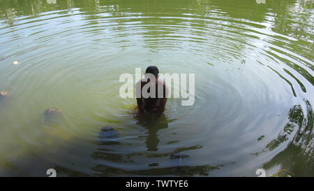 Estate ramna parco 23 giu,2019 Dhaka bangladesh.a uomo sta facendo un bagno nello stagno del parco ramana a causa di esaurimento del calore.Nazmul Islam / alamy stock vivere Foto Stock