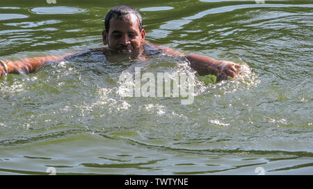 Estate ramna parco 23 giu,2019 Dhaka bangladesh.a uomo sta facendo un bagno nello stagno del parco ramana a causa di esaurimento del calore.Nazmul Islam / alamy stock vivere Foto Stock