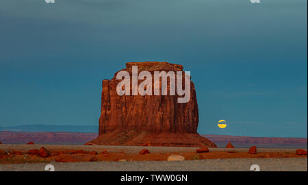 La Monument Valley, Fullmoon in primavera. Rocce Rosse contro il cielo blu di sera. Il parco tribale Navajo nel confine Arizona-Utah, Stati Uniti d'Americ Foto Stock