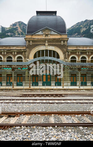 Ingresso vista frontale del abbandonato a Canfranc stazione ferroviaria internazionale e le sue tracce ferroviarie (Canfranc, Pirenei, Huesca, Aragona, Spagna) Foto Stock