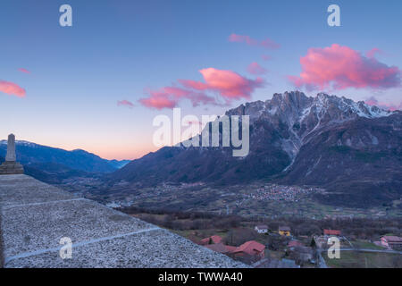 Alba sul comune di Cimbergo in Val Camonica, Italia. Nuvole rosa sopra le montagne, le nuvole colorate all'alba nella valle. Foto Stock