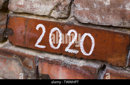 Testo della scrittura a mano 2020 sulla vecchia città rossa muro in mattoni Foto Stock