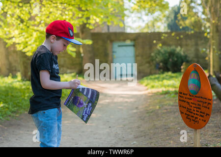 DERBYSHIRE, Regno Unito - 21 Aprile 2019: un piccolo bambino prende parte ad un uovo di Pasqua Caccia al Hardwick Hall Foto Stock