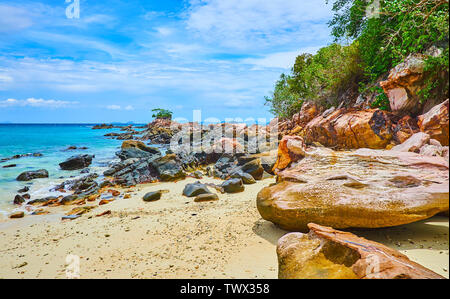 Passeggiata lungo la costa di Khai Nai isola con una vista sulla sabbia bianca e colorata di massi, Phuket, Tailandia Foto Stock