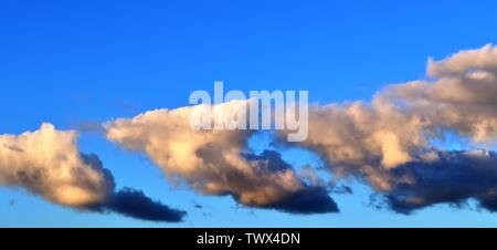 Bel colore arancione tramonto formazioni di nubi con la luce del sole che splende attraverso Foto Stock