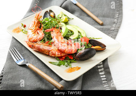 Piastra con una gustosa insalata di pesce sul tavolo Foto Stock