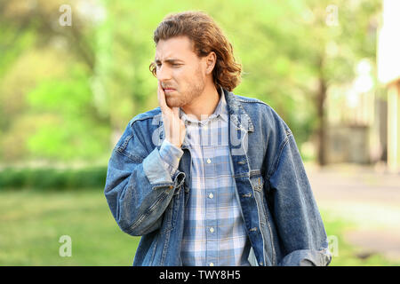 Giovane uomo che soffre di mal di denti esterni Foto Stock