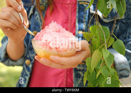 Donna di mangiare saporito rasato ghiaccio all'aperto, primo piano Foto Stock