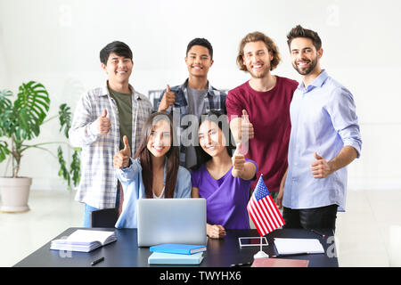 Gruppo di studenti a tavola con il computer portatile in aula Foto Stock