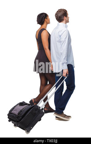 Vista posteriore di interracial andando giovane con la valigia. Vista posteriore di raccolta persone. vista posteriore di persona. Isolato su sfondo bianco. Giovani peopl Foto Stock