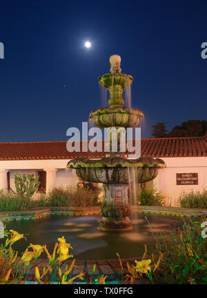 Immagine che mostra la luna piena sorgere palese la costituzione Fontana al San Gabriel missione Playhouse in California. Foto Stock