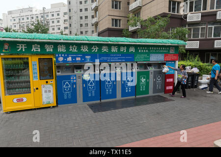 Una donna luoghi spazzatura in uno degli smart garbage-Bidoni di smistamento in una zona residenziale composto a Pechino in Cina. Jun 23, 2019 Foto Stock