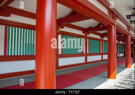 Stile tradizionale giapponese architettura presso un santuario shintoista. Vermillion pilastri colorata linea un corridoio ombreggiato all'antica Hie Jinja santuario, Tokyo Foto Stock