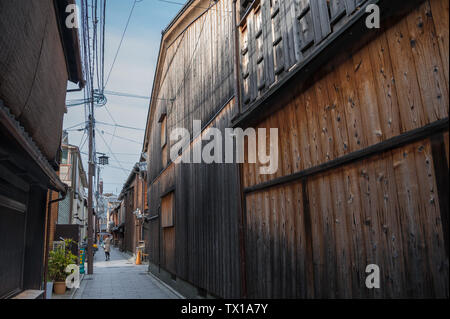 Edo tradizionale architettura di stile nel quartiere di Gion. Donna con ombrello passeggiate lungo la stradina allineata con costruzioni in legno Foto Stock