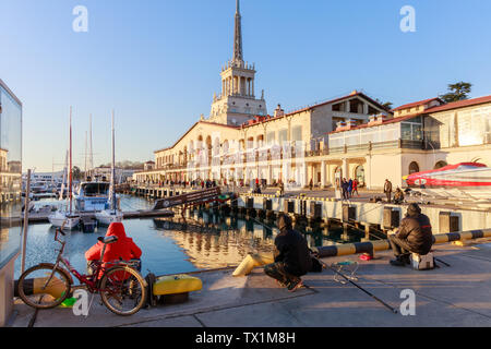 SOCHI, Regione Krasnodar, Russia, Marzo 26, 2019: locali pescare sul molo in background dell'edificio della marina per la stazione passeggeri a su Foto Stock