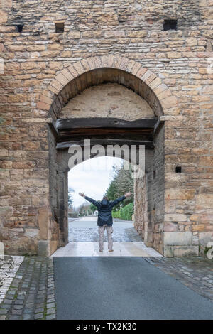 Uomo con le braccia spalancate nel portale della Abbazia di Cluny parete Francia Foto Stock