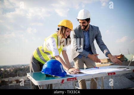 Il gruppo di ingegneri, architetti, business partner a livello di sito in costruzione lavorando insieme Foto Stock