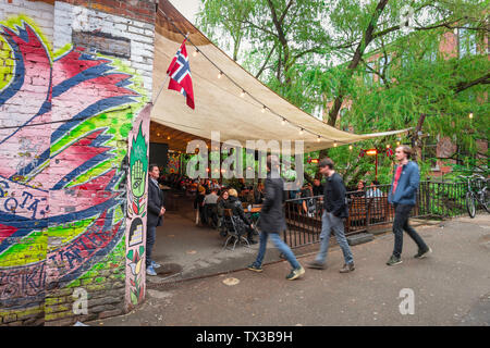 Norvegia bar, vista di giovani che entrano la terrazza sul fiume di Bla - un popolare bar/club di Grünerløkka alternativi nel centro di Oslo, Norvegia Foto Stock