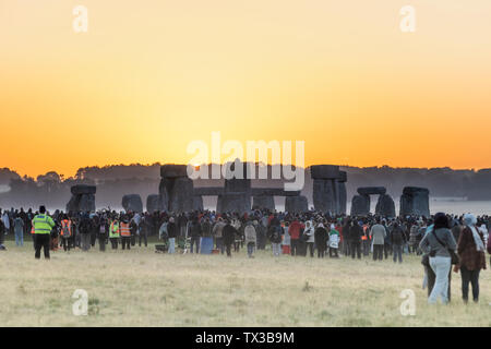 Il 2019 Solstizio d'Estate a Stonehenge, Wiltshire, Regno Unito, vede una folla nella sua migliaia attendere e guardare il sole sorgere sul il giorno più lungo. Foto Stock