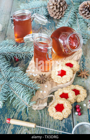 Tre vasi di vetro con marmellata di mirtilli e cookie biscotto con ripieno sullo sfondo delle decorazioni di Natale Foto Stock