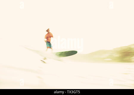 Surfista maschio wave riding di sunny ocean Foto Stock