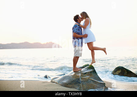 Affettuosa, romantico coppia giovane baciare sulla roccia dell'oceano, Sayulita, Nayarit, Messico Foto Stock