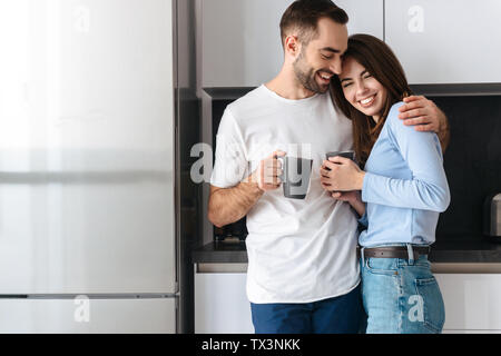 Bella coppia Giovane di bere il caffè mentre si sta in piedi in cucina Foto Stock