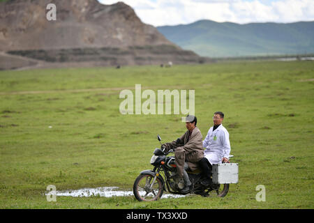 (190624) -- MAQU, Giugno 24, 2019 (Xinhua) -- aiuto medico membro del team Chen Zhifang(R) prende un motociclo per visitare un paziente in Maqu contea di Gannan tibetano prefettura autonoma, a nord-ovest della Cina di Provincia di Gansu, il 23 giugno 2019. Gansu secondo provinciale del popolo ospedale ha inviato oltre 30 medici in quattro lotti per fornire aiuto medico nella contea di Maqu sin dalla fine del 2015. I medici ha superato le difficoltà di malessere da altitudine e scomodo il trasporto durante il trattamento di pazienti sui prati dell'altopiano. Aver servito quasi 10 000 persone finora, il team medico ha risolto i pastori' d Foto Stock