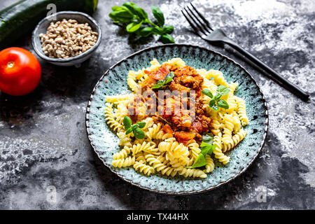 Spirelli con bolognese vegetariana, girasole tritare, zucchine, pomodori, parmigiano e basilico Foto Stock